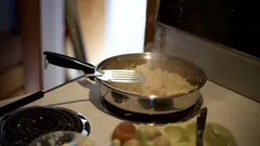 Ruostumattomasta teräksestä valmistettu haarukka mustalla paistinpannulla